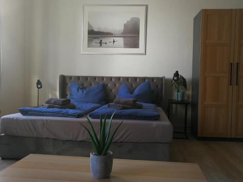 a bedroom with a bed with blue pillows at City Appartements Köthen in Köthen