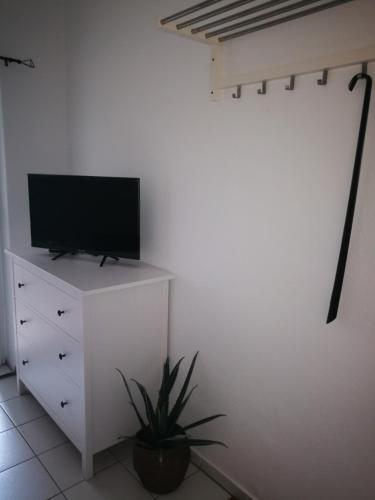 a television on a white dresser in a room at City Appartements Köthen in Köthen