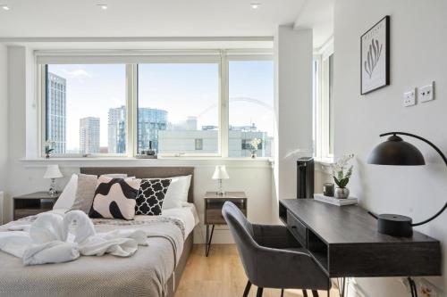 a bedroom with a bed and a desk and a window at Luxury 3-Bed Apt in Wembley Park in London
