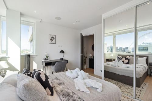 a bedroom with two beds and a desk at Luxury 3-Bed Apt in Wembley Park in London