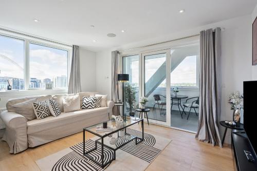 a living room with a couch and large windows at Luxury 3-Bed Apt in Wembley Park UpTo 30 percent OFF in London
