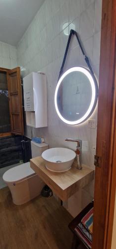 a bathroom with a sink and a toilet and a light at Villa Josefina in Puerto Lápice
