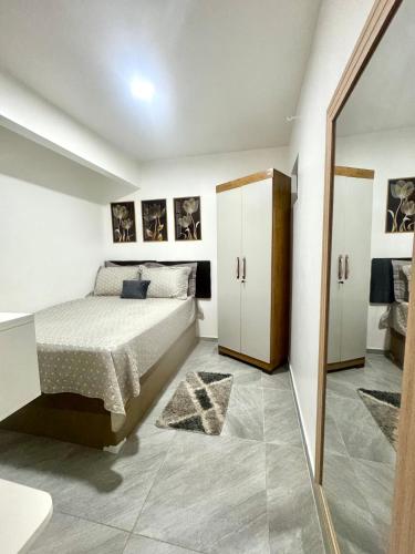 a bedroom with a bed and a mirror at Suite aconchego Belém in Una
