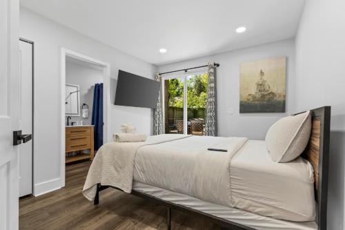 a white bedroom with a large bed and a window at 4BR Bright and Modern - Close to Everything in Charlotte