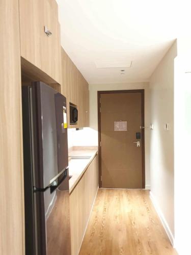 a kitchen with a refrigerator and a wooden floor at Novotel Hotel Residences Manila by AMORE Suites in Manila
