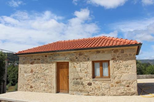 a small stone house with a red roof at Villa Barbosa in Quintiães