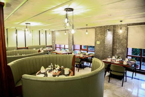 a restaurant with tables and chairs in a room at Hotel Preethi Classic Towers in Ooty