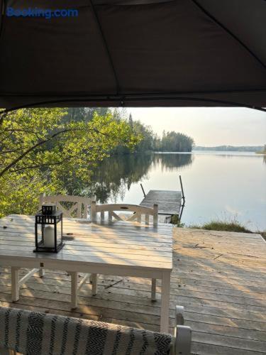 a picnic table on a dock with a view of a lake at Family Friendly Villa near the Water in Katrineholm