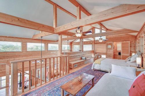 a living room with wooden walls and a couch and a table at Cliffside Cabin @ High Hope Ranch Cowboy POOL! in Glen Rose