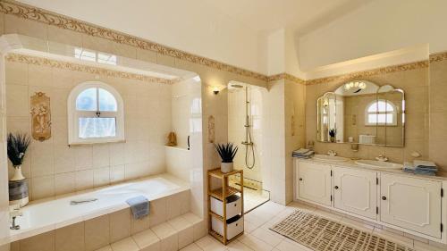 a bathroom with a tub and a sink and a mirror at Villa Verde by Check-in Portugal in Vilamoura