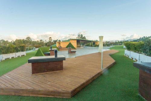 a wooden deck with benches on top of a field at Hotel Rioverde-Suite localizada a 5 minutos del aeropuerto Internacional in Rionegro