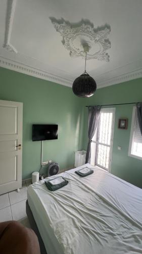 a bedroom with a bed and a green wall at Anfa Training Bed and Breakfast in Bouznika