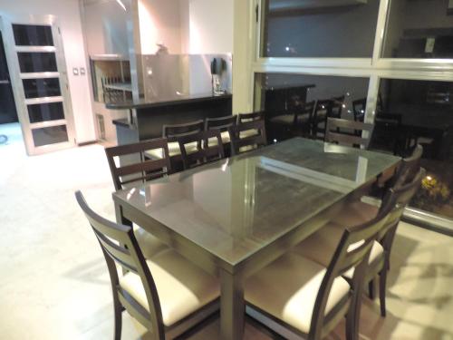 a dining room with a glass table and chairs at Apart Belgrano in Posadas
