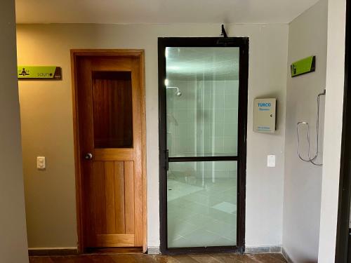 a glass shower in a room next to a door at Hotel Rioverde-Suite localizada a 5 minutos del aeropuerto Internacional in Rionegro