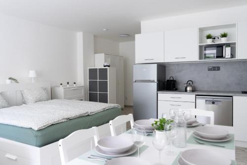 RejÅ¡tejnにあるLa Via Natura Apartmány Rejštejnのベッドとテーブルと椅子のある寝室