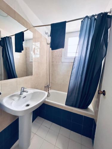 a bathroom with a sink and a shower curtain at Apartaments Monjardí in Lloret de Mar