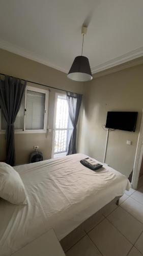 a bedroom with a large white bed with a window at Anfa Training Bed and Breakfast in Bouznika