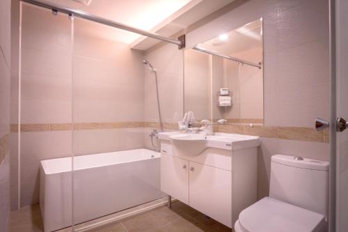a bathroom with a sink and a toilet and a shower at Mesasa Garden Motel in Ji'an