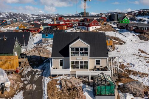 a house on top of a hill with snow at Ilulissat Stay - Nanna's Villa - 1 in Ilulissat