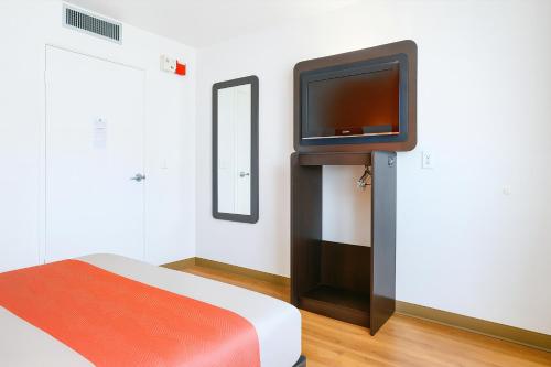 a room with a bed and a tv on a wall at Motel 6-Carlsbad, CA Beach in Carlsbad