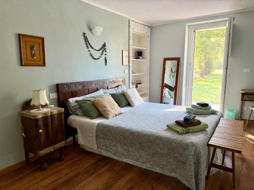 a bedroom with a bed and a window at Il Murôn Guest House in Carentino