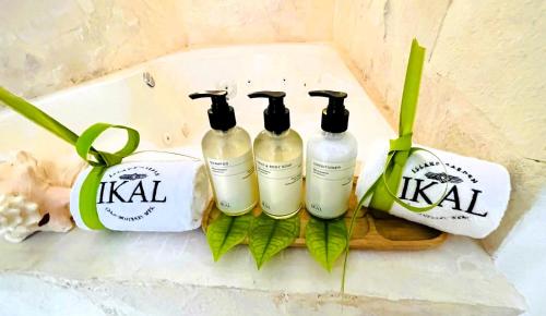 a group of three bottles ofikiiki products sitting on a counter at Ikal Island Garden in Isla Mujeres