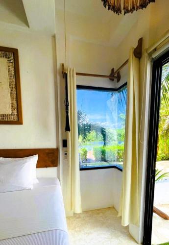 a bedroom with a bed and a large window at Ikal Island Garden in Isla Mujeres