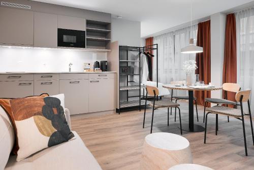 a kitchen and living room with a table and chairs at Stay Sunday in Zürich