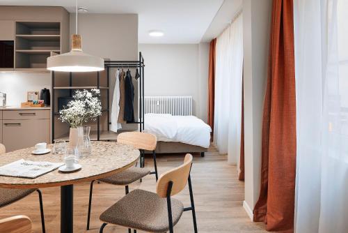 a room with a table and chairs and a bed at Stay Sunday in Zürich