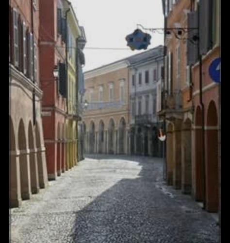 an empty alley with buildings in a city at Homecoming apartment in Guastalla