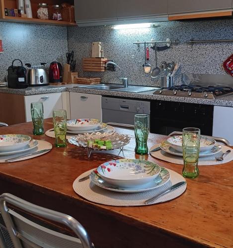 a table with plates and dishes on it in a kitchen at Homecoming apartment in Guastalla