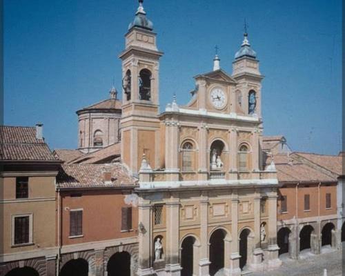 a building with a clock tower on top of it at Homecoming apartment in Guastalla