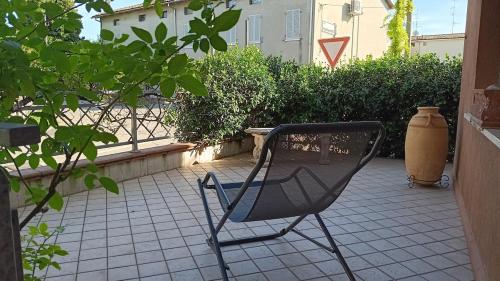 a black chair sitting on a tile patio at Homecoming apartment in Guastalla