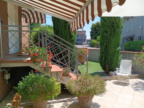 a patio with two potted plants and a staircase at Homecoming apartment in Guastalla
