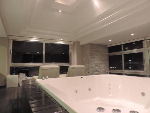a large white bath tub in a room with windows at Apart Belgrano in Posadas