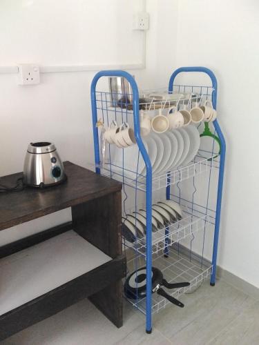 a rack of plates and dishes in a kitchen at Mayon Guest in Tangalle