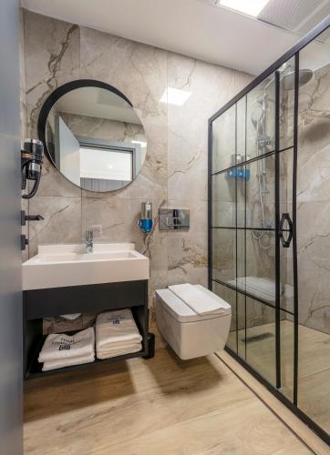 a bathroom with a sink and a toilet and a mirror at The Private Airport Hotel in Istanbul