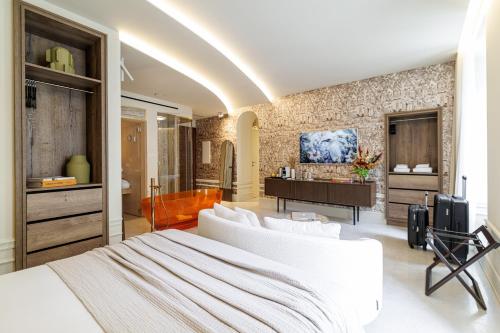 a bedroom with a white bed and a bathroom at Le Dortoir Boutique Suites in Nice