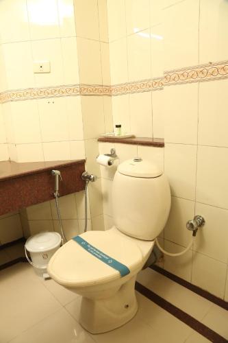 a bathroom with a toilet with a blue ribbon on it at Hotel Preethi Classic Towers in Ooty