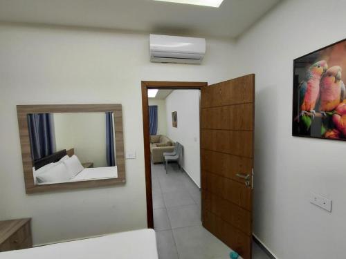 a room with a mirror and a door with a room with a room at Amchit Grand Hotel in Al Qarfī