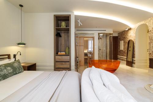 a bedroom with a bed and a tub at Le Dortoir Boutique Suites in Nice
