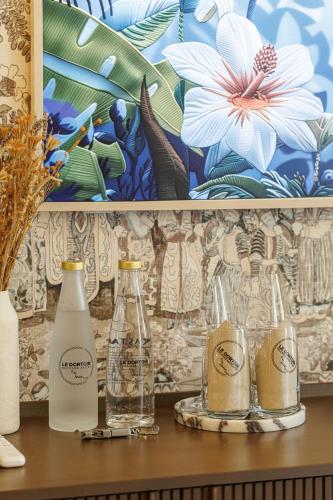 a shelf with bottles and glasses on a table at Le Dortoir Boutique Suites in Nice
