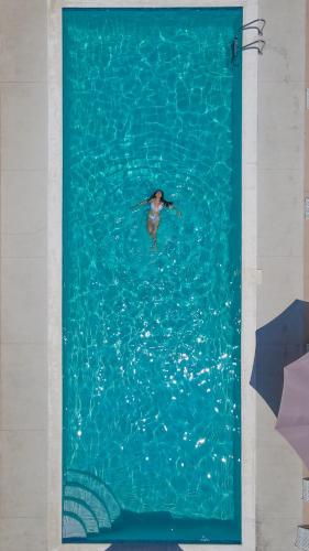 a bird swimming in a pool of water at The Views Resort in El Zonte