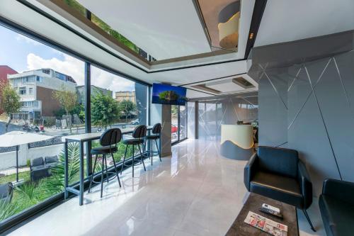a room with chairs and a balcony with windows at The Private Airport Hotel in Istanbul