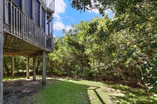 a house with a deck and a yard with grass at 8455 - Mad Hatteras in Avon