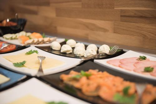 einen Tisch mit verschiedenen Lebensmitteln auf Platten in der Unterkunft Parkhotel Schillerhain in Kirchheimbolanden