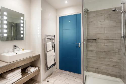 a bathroom with a shower and a blue door at The Daffodil Hotel & Spa in Grasmere