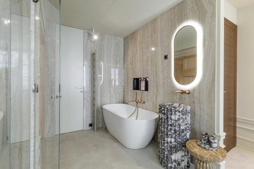 a bathroom with a tub and a mirror at Le Dortoir Boutique Suites in Nice
