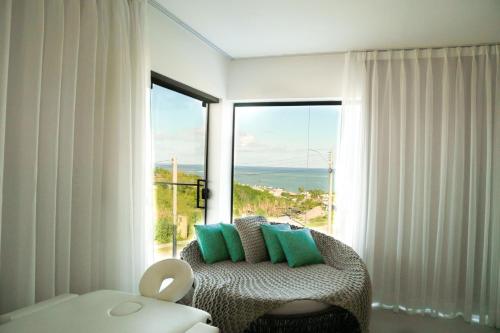 une pièce avec une chaise et une grande fenêtre dans l'établissement Casa em Milagres/AL | 3 suítes, vista-mar, piscina, à Barra do Camaragibe