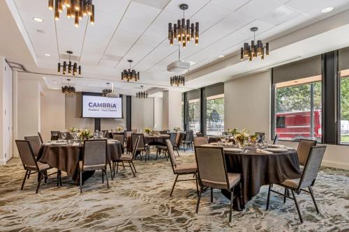 a conference room with tables and chairs and a projection screen at Cambria Hotel Portland - Pearl District in Portland